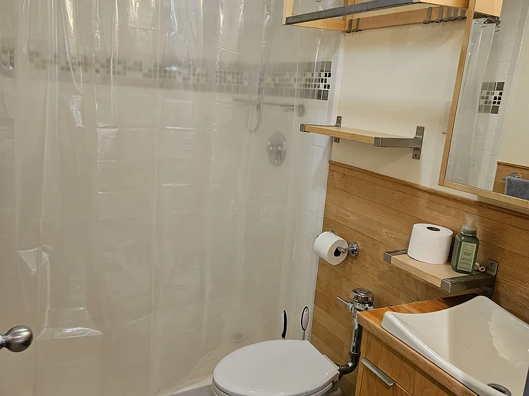 Large tiled shower showcase a wood-paneled bath.