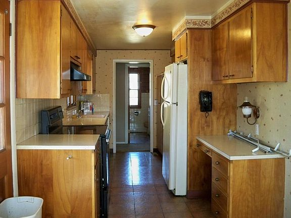 Kitchen with refrigerator, electric cook top range, and dishwasher.