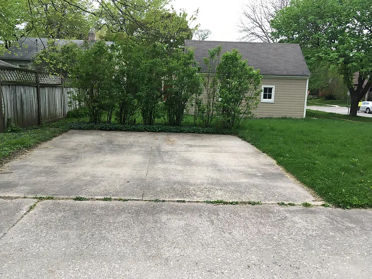 Two extra parking spots with lilac bushes giving privacy to the backyard and patio.