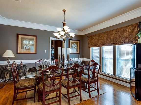 The elegant dining room features nail down wood floors, double crow molding and chair rail molding.