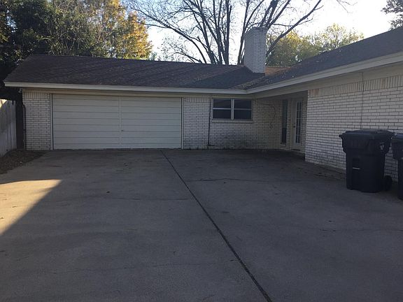 Back of house with 2 car garage and back door