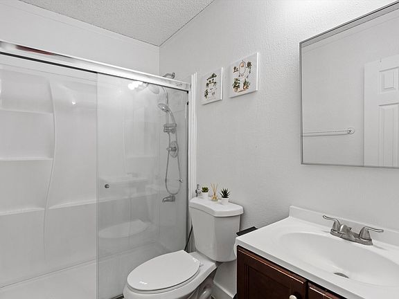 A bright, clean bathroom with a walk-in shower, modern vanity, and thoughtful accents. Perfect for unwinding after a day out