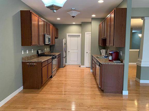 View of kitchen from dining area. Door at back opens to mud room w/W/D hookups and large coat closet. Garage on other side of mud room. Partial door view is the pantry. Refrigerator is included in the rent. Side by side with bottom freezer and ice maker.