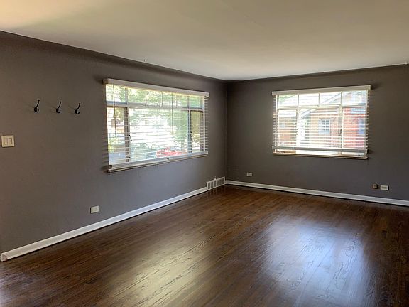 The spacious living room at 2211 S. GIlpin St. measures 20'9" by 13'4" has been beautifully maintained. Its highlights include original red oak hardwood floors, large windows that let in ample natural light, coved ceilings, sophisticated paint, original