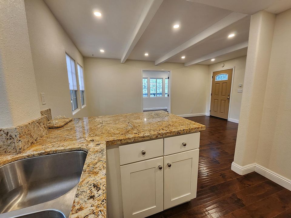 Luxury quartz countertops with breakfast bar that looks in the living room.