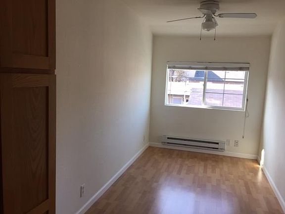 Living room with ceiling fan, electric baseboard heater