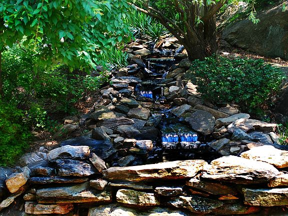 Cascading waterfall, meanders through the landscaped garden from the upper pla