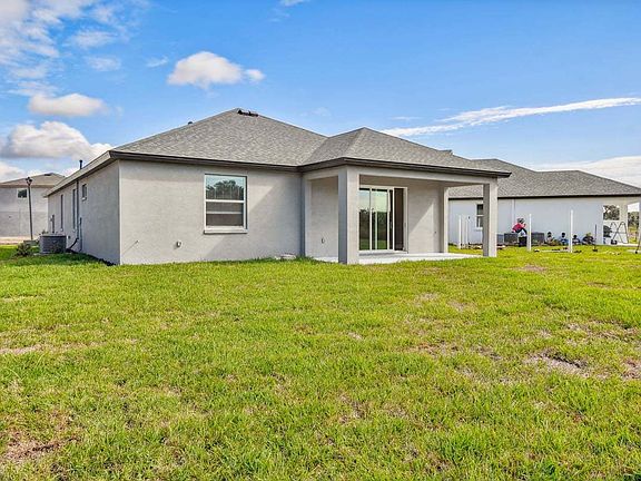 Sanibel quick move-in new construction home rear left view covered lanai at Tea Olive Terrace Palmet