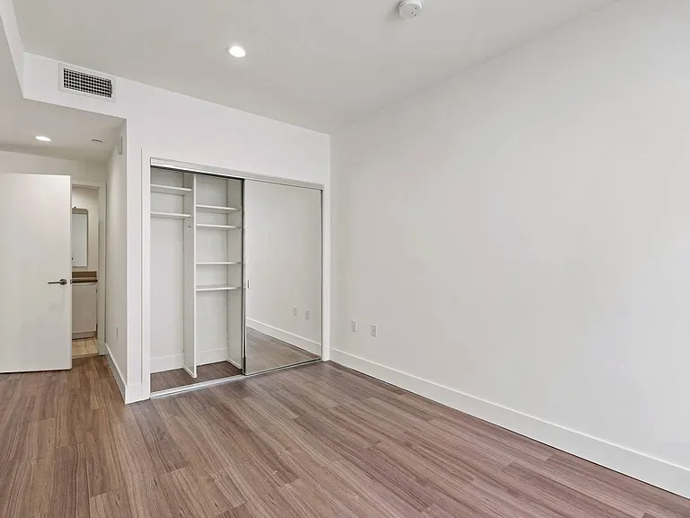 Bedroom with Mirrored Closet with Shelving