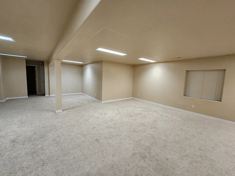 Looking from stairs in Downstairs Rec Room - View of entrance to hallway leading to 2 Bedrooms and the Bathroom