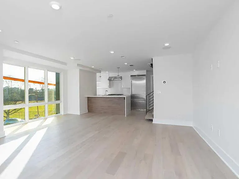 This is a large living room with kitchen in the back.