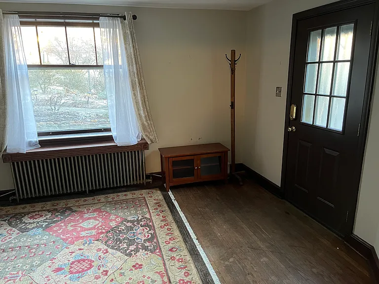 Wood floors and large picture window frames the front garden