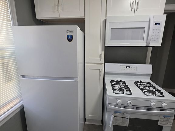 2nd Kitchen view, showing additional cabinets outlining the refrigerator, stove and microwave.