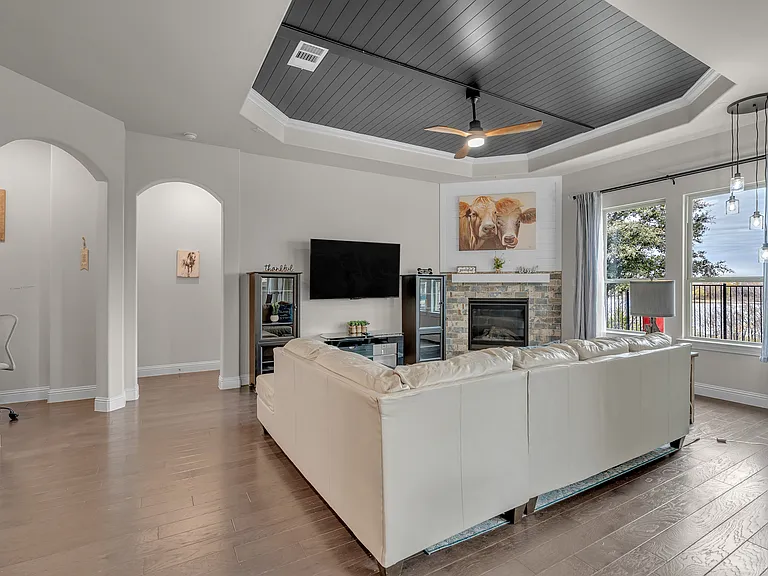 Office alcove on the left, entrance to master bedroom suite next to that, and open floorplan living room with backyard and lake views. Solid wood floors.