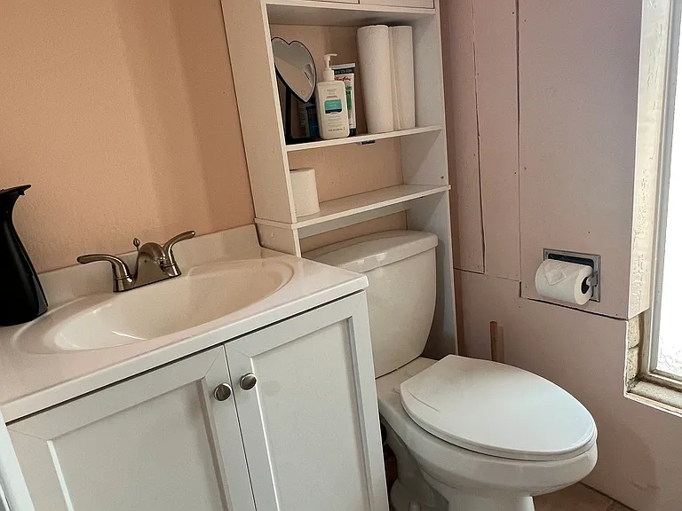 Single bathroom with sink, toilet and stall shower. Several storage areas and lots of natural light.