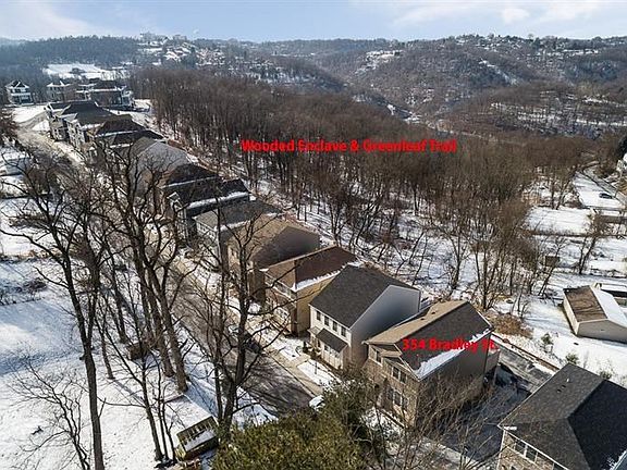 Aerial view overlooking green space behind property.