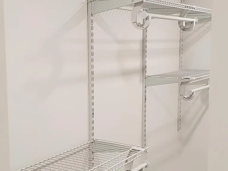 Downstairs bedroom has walk-in closet with shelving and hanging racks