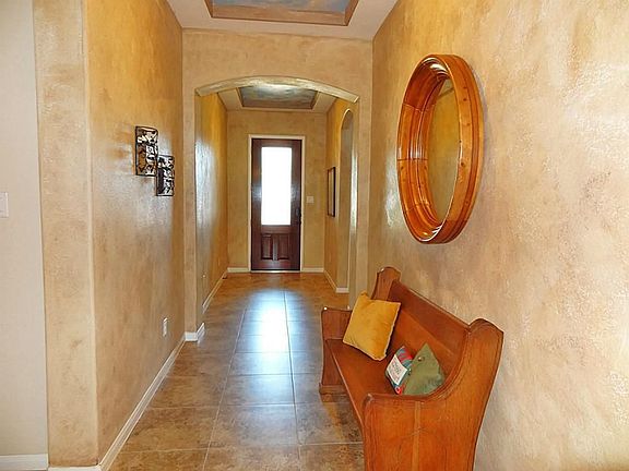 Leaded glass front door welcomes guests into this impressive foyer.  Ceramic tile floor, high ceiling, & custom decorator faux painting. Notice the arched openings, rounded corners, and coffered ceilings throughout the home.