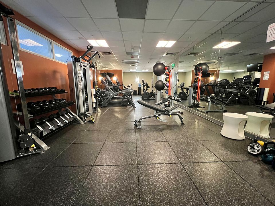 gym with free weights, treadmills, and machines