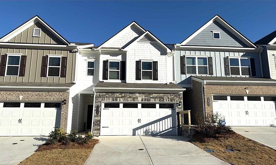 Craftsman-style house with board and batten siding, concrete driveway, and an attached garage