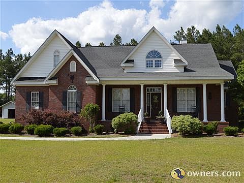Brick home with front porch and professional landscaping