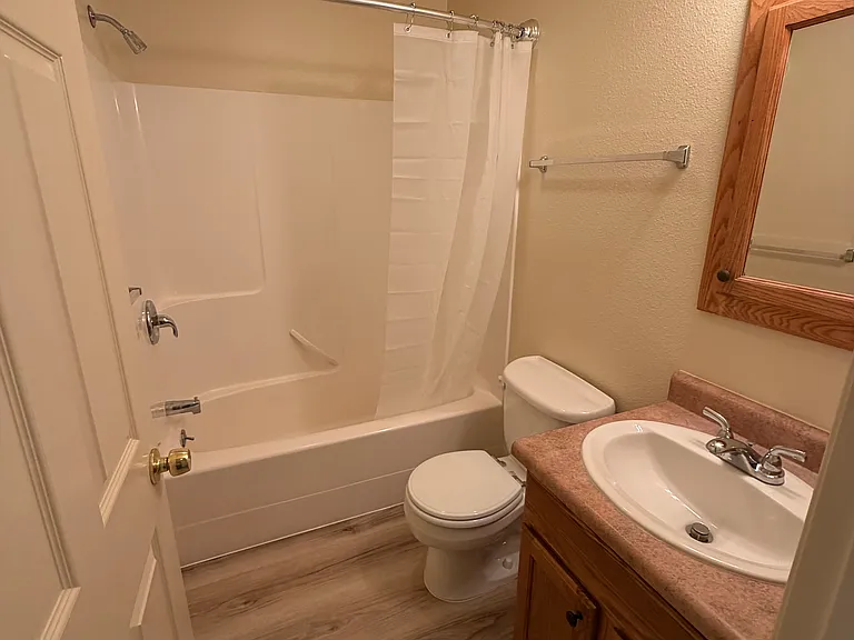 Master bathroom with curved shower curtain rod for more elbow room.
