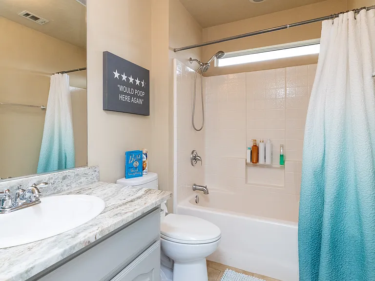 Clean and bright bathroom with a tub/shower combo, fresh towels, and essential toiletries. Simple and comfortable for everyday use.