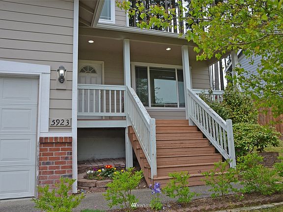front of house with flower beds and porch with sitting room>