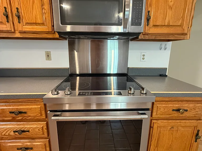 Brand new Maytag smooth top stove, microwave and new stainless backsplash