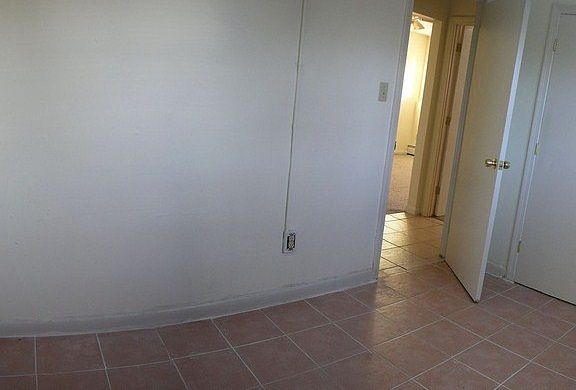 Second bedroom has ceiling fan and is tiled