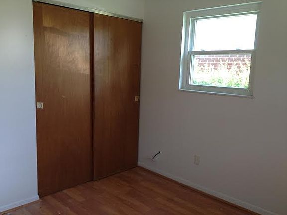 A bedroom with Laminate flooring and the closet