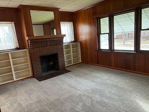 Living room with built in bookcases and decorative fireplace.