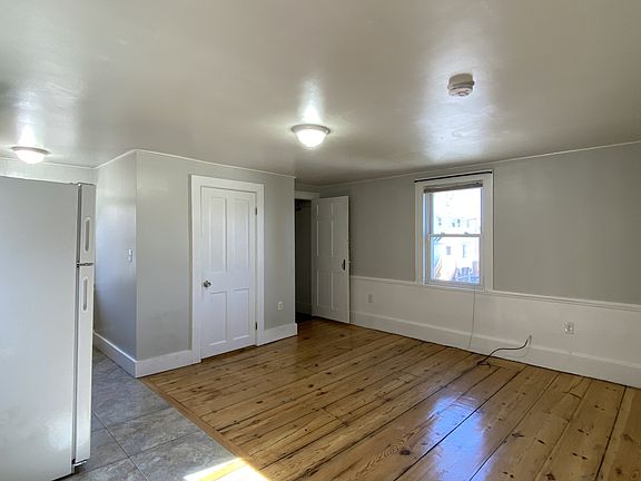 View from Entrance, original wide plank wood flooring, windows and abundant natural light.