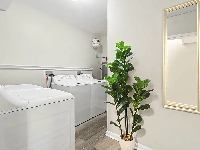 Dedicated laundry area with full-size washer and dryer hookups, durable flooring, and convenient access from the hallway.