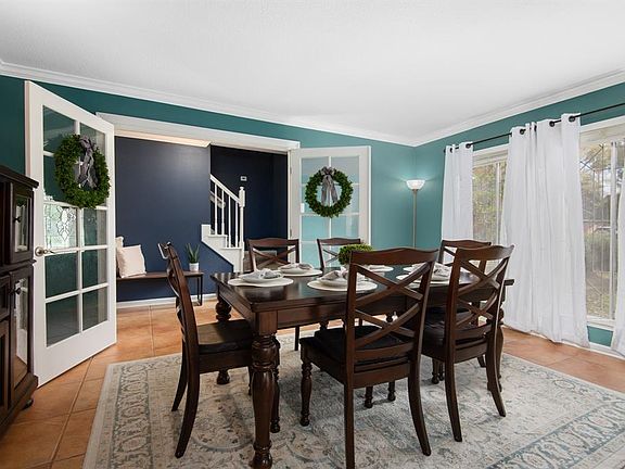 Just off of the entryway, through beautiful French doors is this spacious room with leaded-glass windows, being used here as a dedicated dining space.