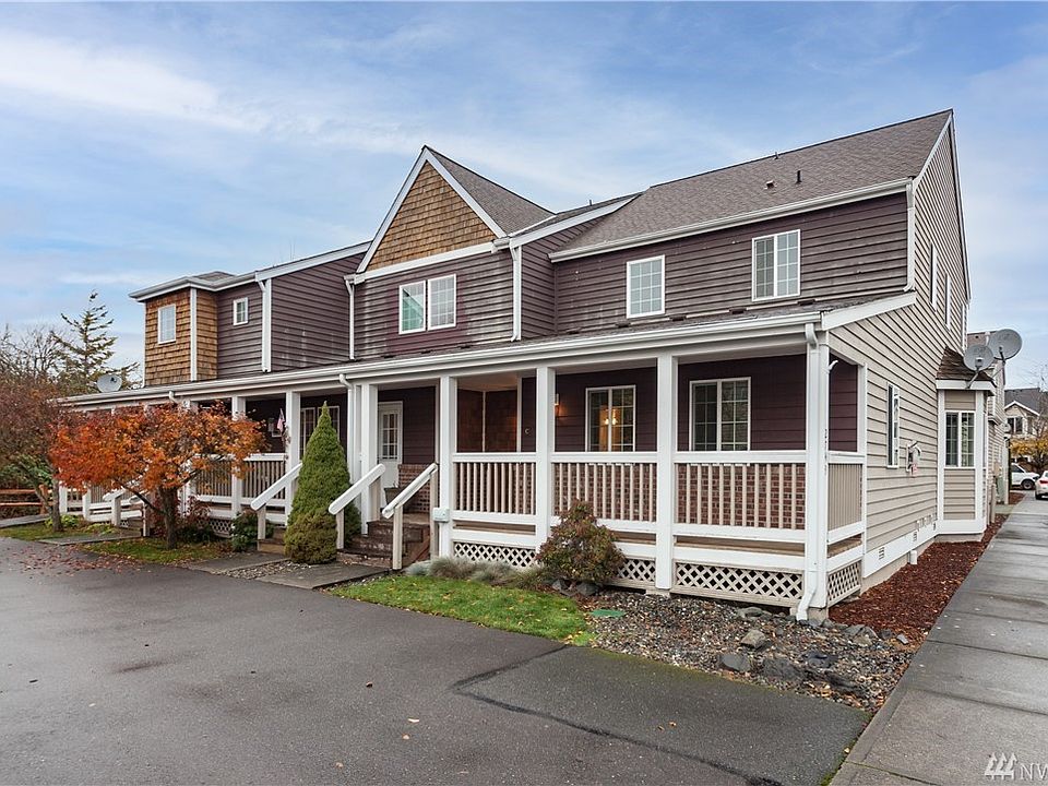 Two story end unit townhome in a 12 unit complex.  Notice the covered porch, and there's an off-street parking lot in front of the building (in adition to the 2-car attached garage)