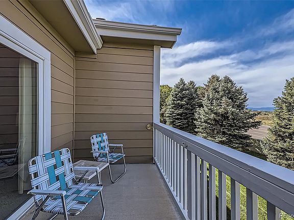 The outdoor balcony is accessible from the living room or the primary bedroom and overlooks open space and a golf course