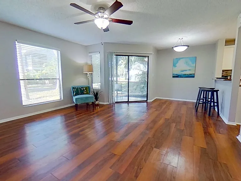 Experience a bright and open living space in The Newport Autograph floor plan. This living room offers plenty of natural light, wood-style flooring, and easy access to the private patio, perfect for relaxation and entertaining.
