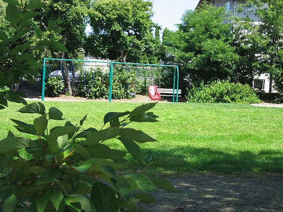 The playground is next to the apartment.