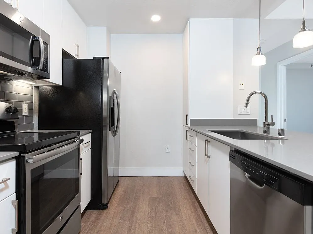 Renovated Phase I kitchen with stainless steel appliances and hard surface flooring - Avalon at Mission Bay