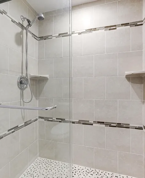 The master bathroom offers a sleek, modern shower with elegant fixtures and glass enclosure, creating a bright and refreshing space to start your day. A built-in medicine cabinet provides convenient storage for toiletries and essentials.