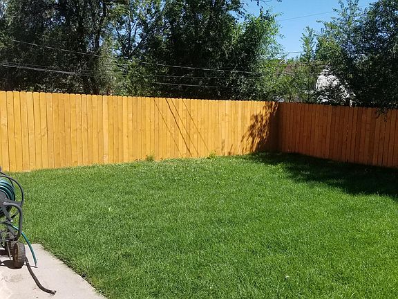 Fenced backyard with sprinkler systems.