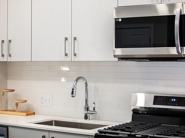 Modern kitchens with stainless steel appliances, white quartz countertops, and light grey cabinetry