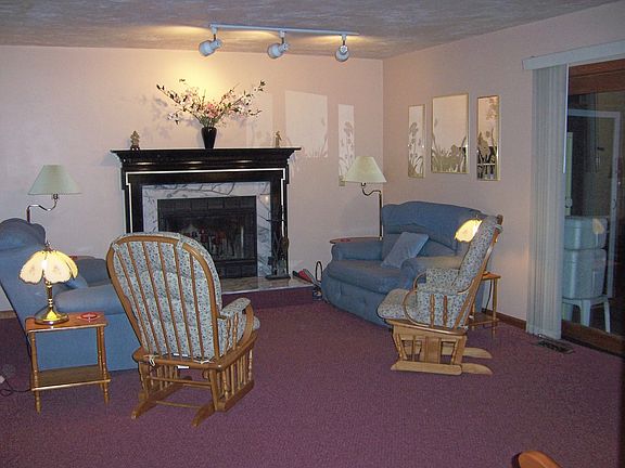 Living rm with marble fireplace, French doors to deck