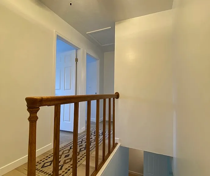 Upstairs hall outside two bedrooms with fan and light.