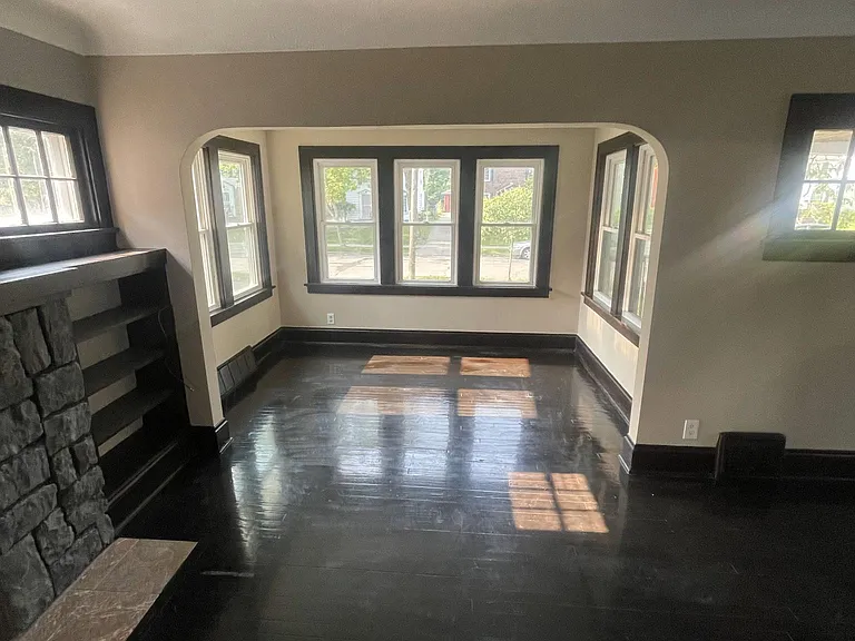 Large living room looking towards office nook with plenty of natural light