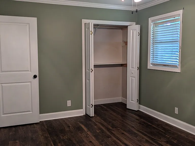 Rear bedroom with ceiling fan and closet