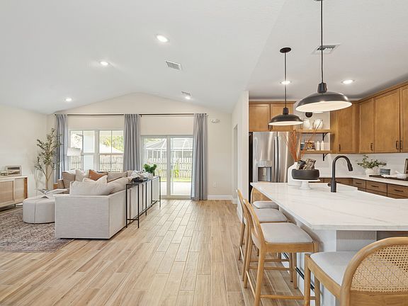 Kitchen overlooking great room and dining area with vaulted ceiling