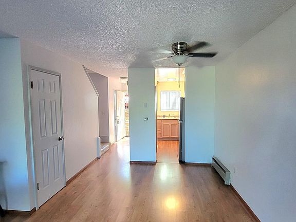 Living room, looking towards front door entrance and kitchen. Downstairs closet and half bath.