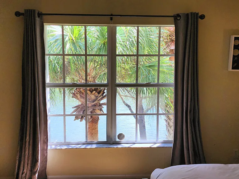 Spacious master with lake view, natural light, and comfortable king bed.